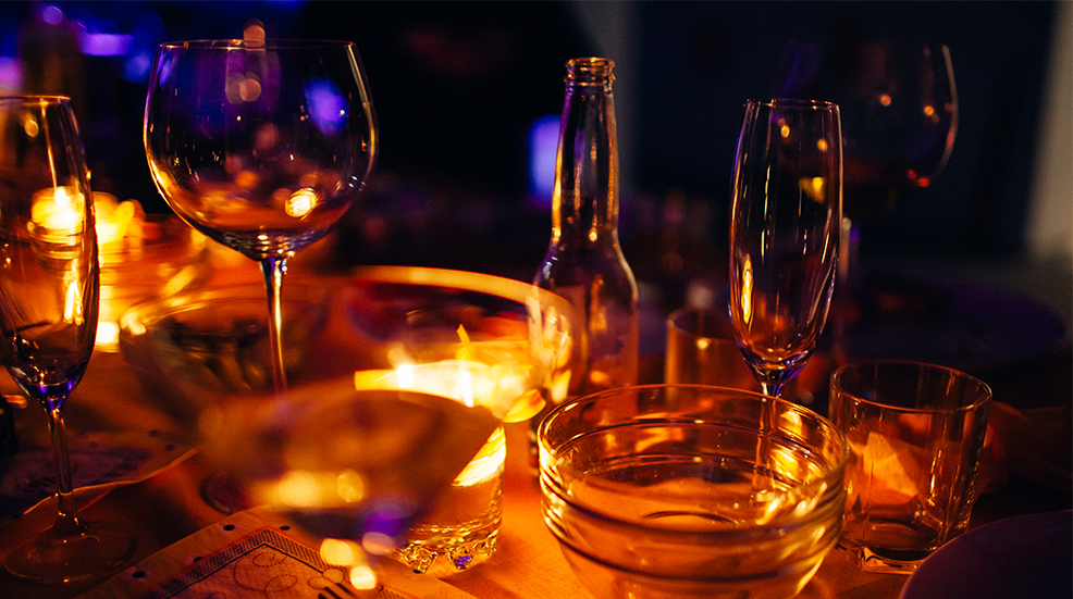 Horizontal close-up of beautiful table decoration illuminated by the warm candlelight